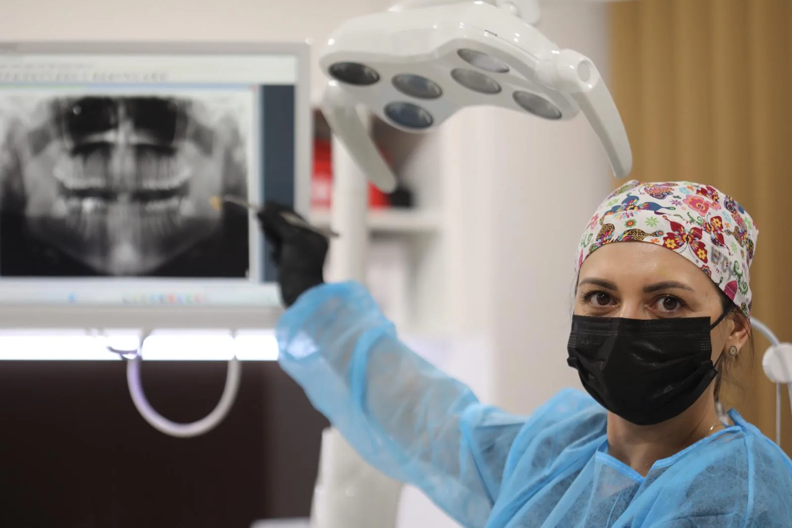 Medic Oralis arătând o radiografie panoramică pe ecran